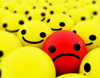 pictures for how you feel a unhappy face in a sea of happy faces.webp