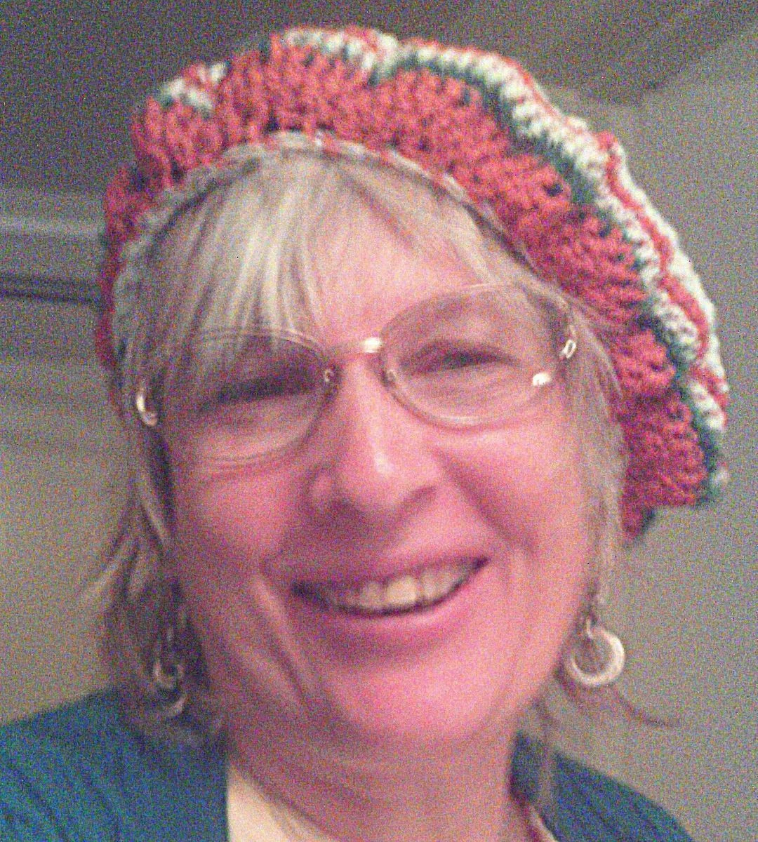 Shiela in her own croched hat smiling.webp